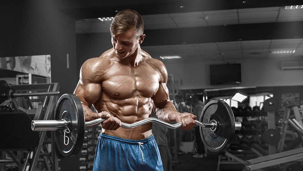 Muscular Guy in Ble Shorts Doing a Barbell Bicep Curl